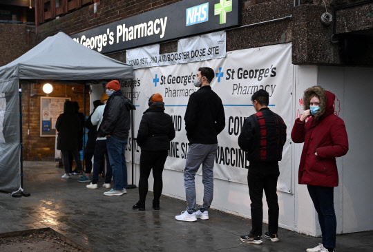 오미크론 감염 급증에 부스터샷 접종 속도 내는 영국      (런던 EPA=연합뉴스) 영국이 신종 코로나바이러스 감염증(코로나19) 오미크론 변이 확산으로 비상인 가운데 13일(현지시간) 코로나19 백신 3차 접종(부스터샷)을 하려는 시민들이 접종소 앞에 길게 줄지어 서 있다. 영국은 전날 기준 코로나19 오미크론 변이 감염자 수가 첫 사례 보고 후 2주 만에 3천 명을 돌파했다. 이에 영국 정부는 코로나19 경보 등급을 3단계에서 4단계로 격상하고 부스터샷 접종에 속도를 내고 있다. 2021.12.13      sungok@yna.co.kr  (끝)